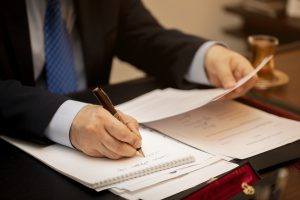 Notario revisando documentos de donación con un cliente en Ávila